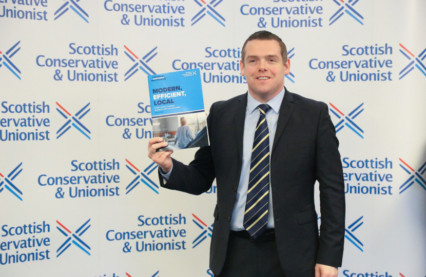 Douglas holds policy booklet
